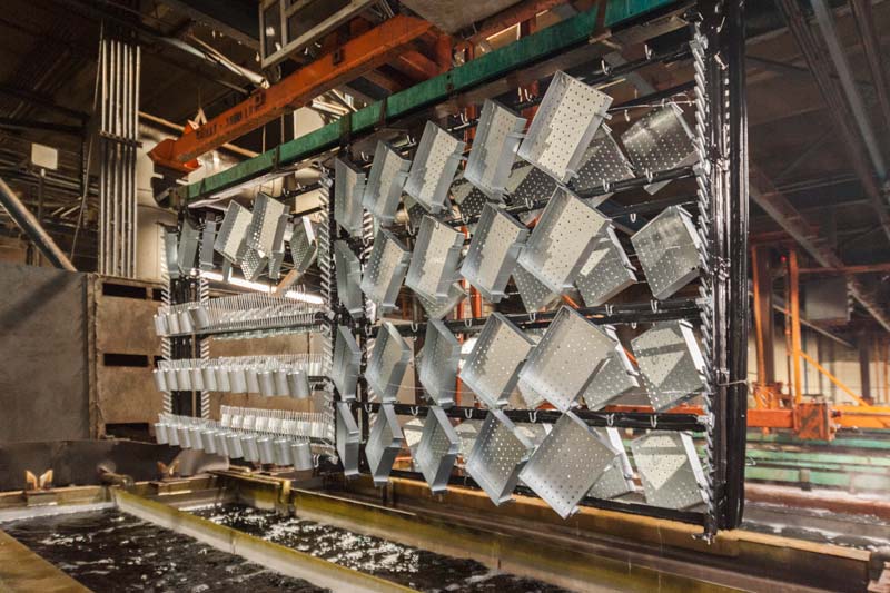 A variety of parts are attached on an automated metal plating rack.
